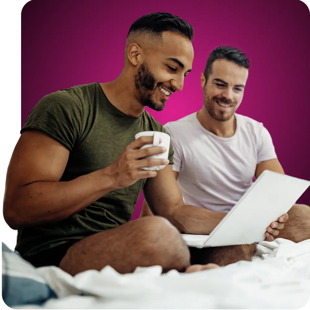 Gay couple smiling and looking at Q Care Plus.com